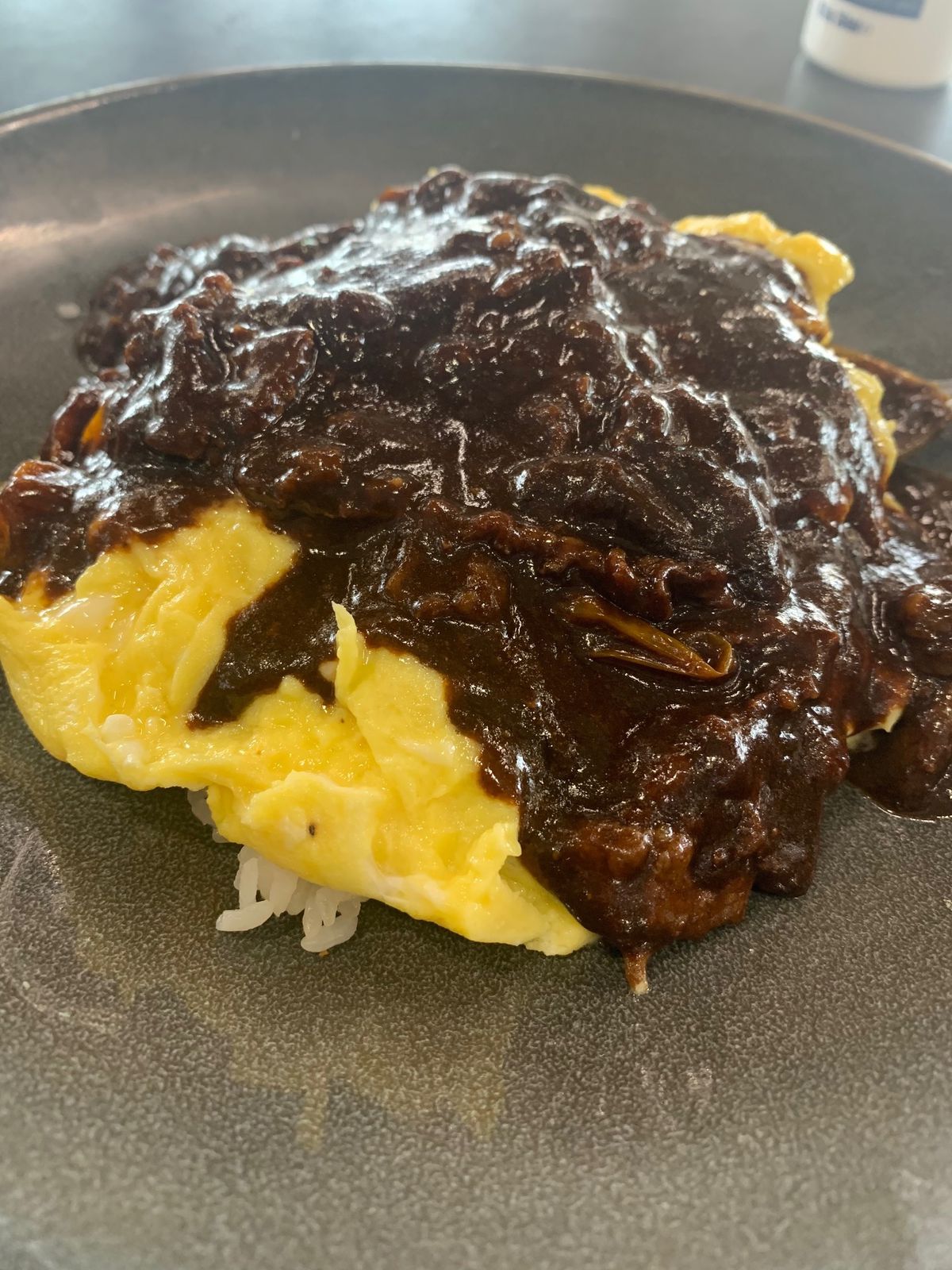 Japanese black curry on top of omurice (an omelette wrapped around a mound of white rice)