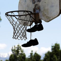 Shoes hang from a basketball rim at Pioneer Park in Salt Lake City on Wednesday, June 1, 2016.