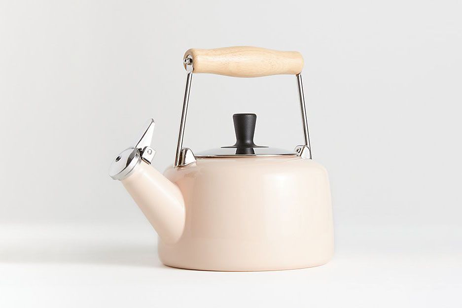 A light pink kettle with a wooden handle