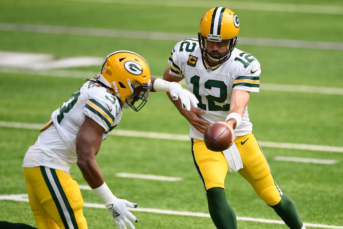 Aaron Rodgers  of the Green Bay Packers hands the ball to Aaron Jones as they warm up before the game against the Minnesota Vikings at U.S. Bank Stadium on September 13, 2020 in Minneapolis, Minnesota.