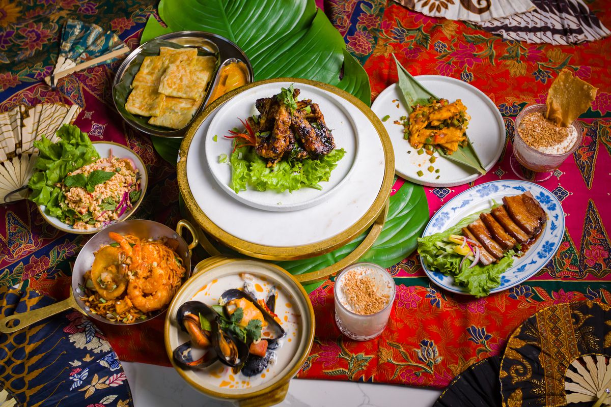 A spread of dishes on a colorful background at the Southeast Asian restaurant Wau