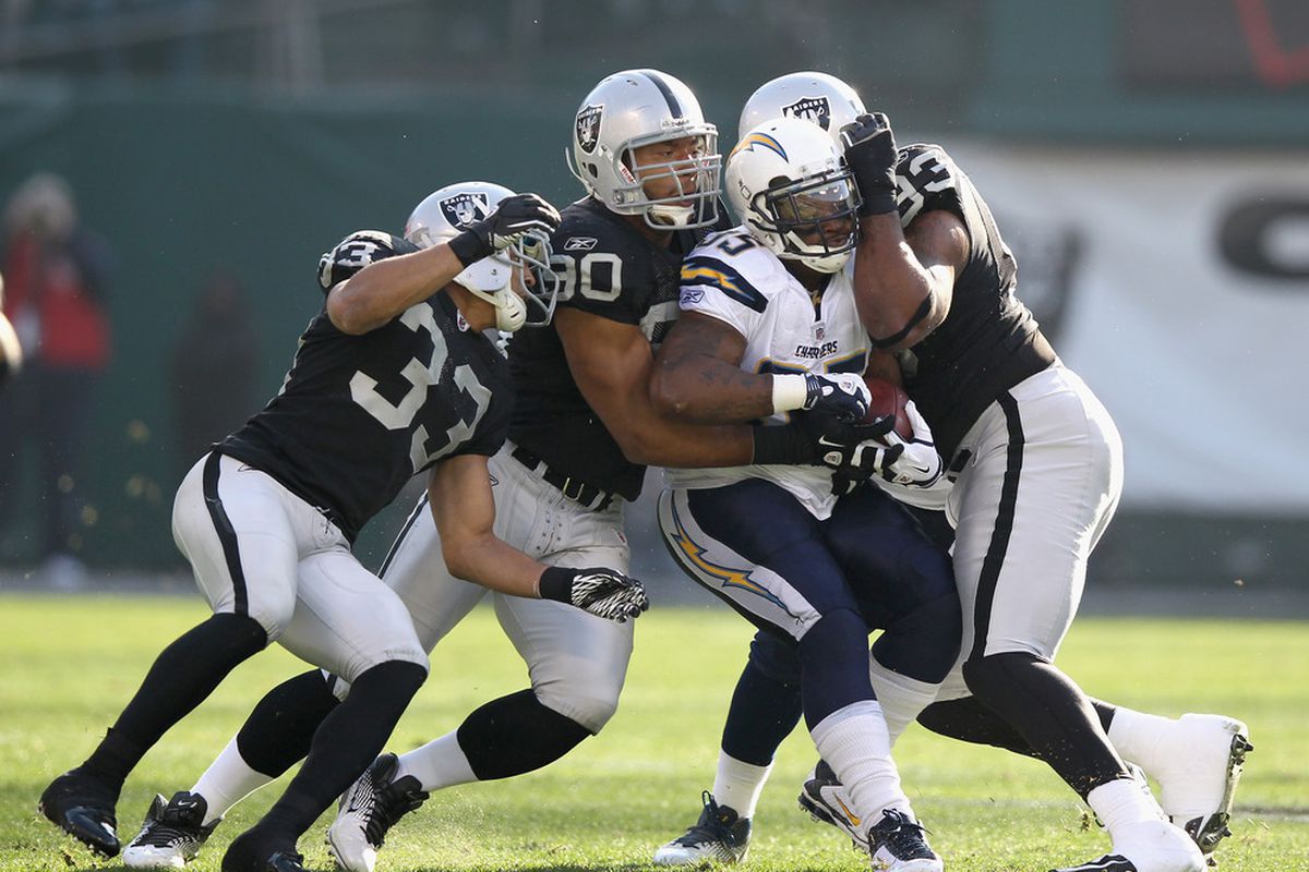 Mike Tolbert #35 of the San Diego Chargers is gang tackled by several Oakland Raiders
