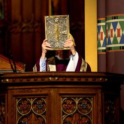Deacon Ricardo Arias raises the Bible during the noon Mass on Ash Wednesday at the Cathedral of the Madeleine in Salt Lake City on Wednesday, Feb. 18, 2015.