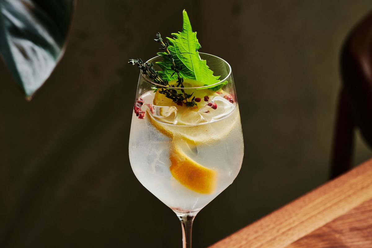 A gin and tonic loaded with thyme, lemon peel, and shiso leaf at Uchi.