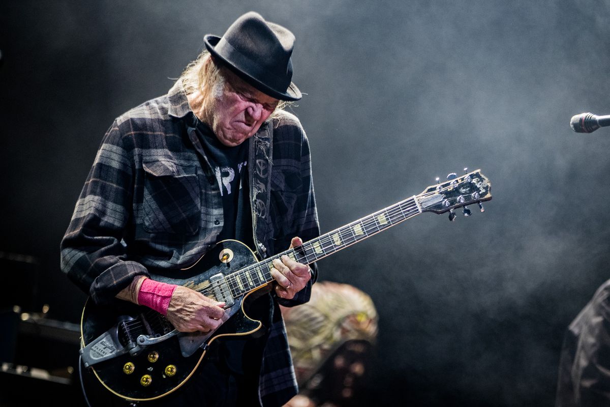 Neil Young onstage playing guitar.