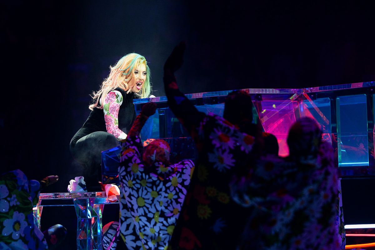 Lady Gaga sings while sitting at a grand piano onstage