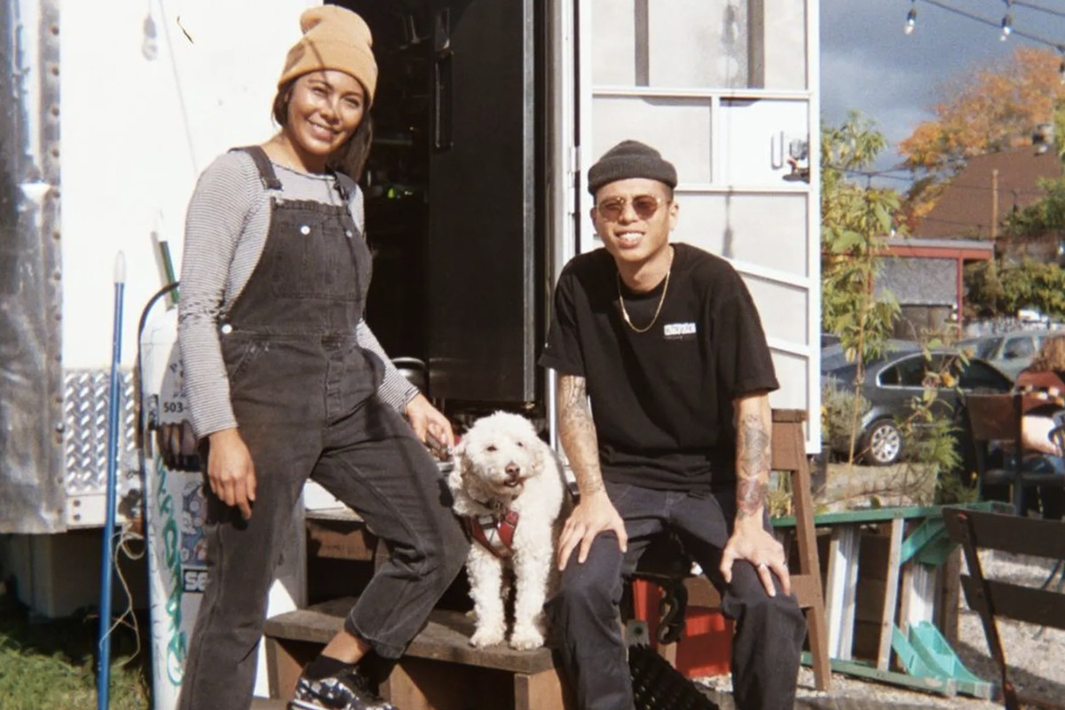 Portland food cart owners Richard and Sophia Le pose outside their food cart, Matta, with their dog.