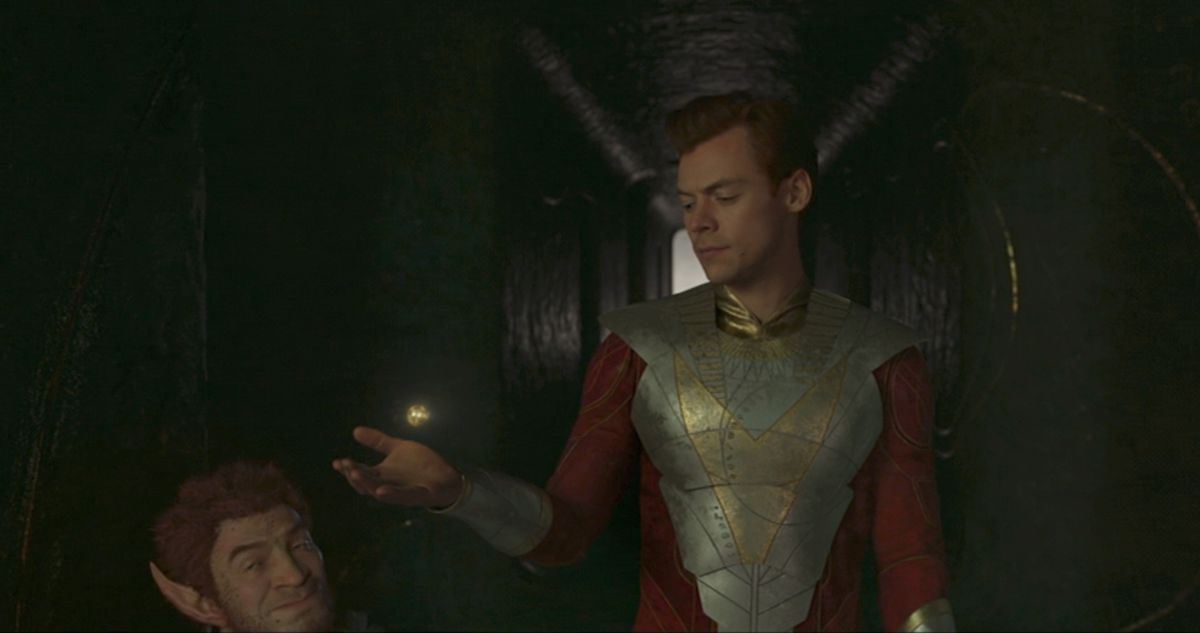 Eros (Harry Styles) contemplates an orb next to Pip the Troll in a shot from Eternals