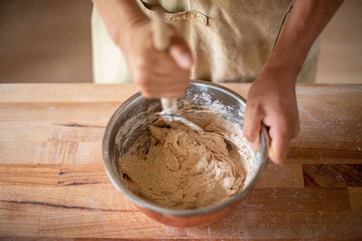 A baker mixed ingredients in a large bowl.