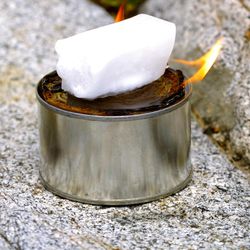 Set a piece of wax on the can and light a match next to the wax. Add wax until the burner is filled.