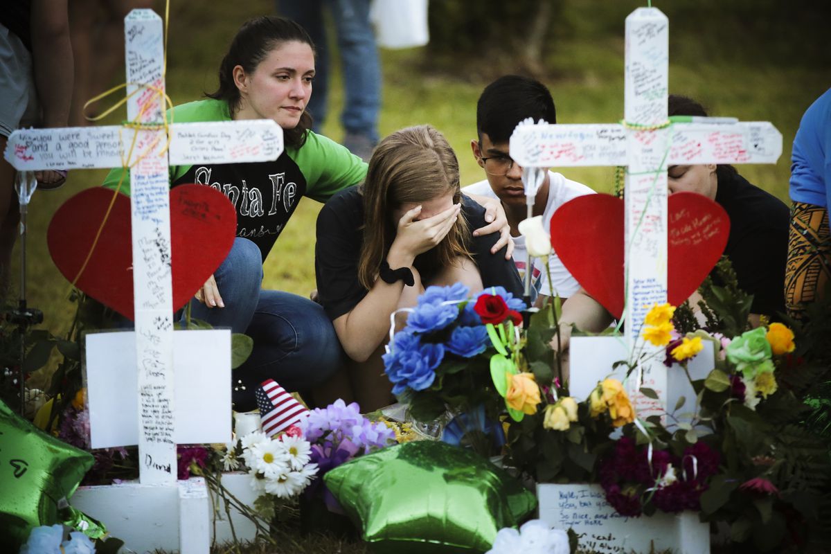 Mourners visit a memorial in front of Santa Fe High School on May 21, 2018, in Santa Fe, Texas. The makeshift memorial honors the victims of the May 18 shooting, in which a student entered the school with a shotgun and a pistol and opened fire, killing 10