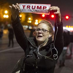 A Trump supporter shows her colors to protestors marching during an anti-Trump protest in Salt Lake City on Thursday, Nov. 10, 2016. Hundreds of protestors took to the streets to denounce the president-elect, ultimately making their way to the state Capitol.