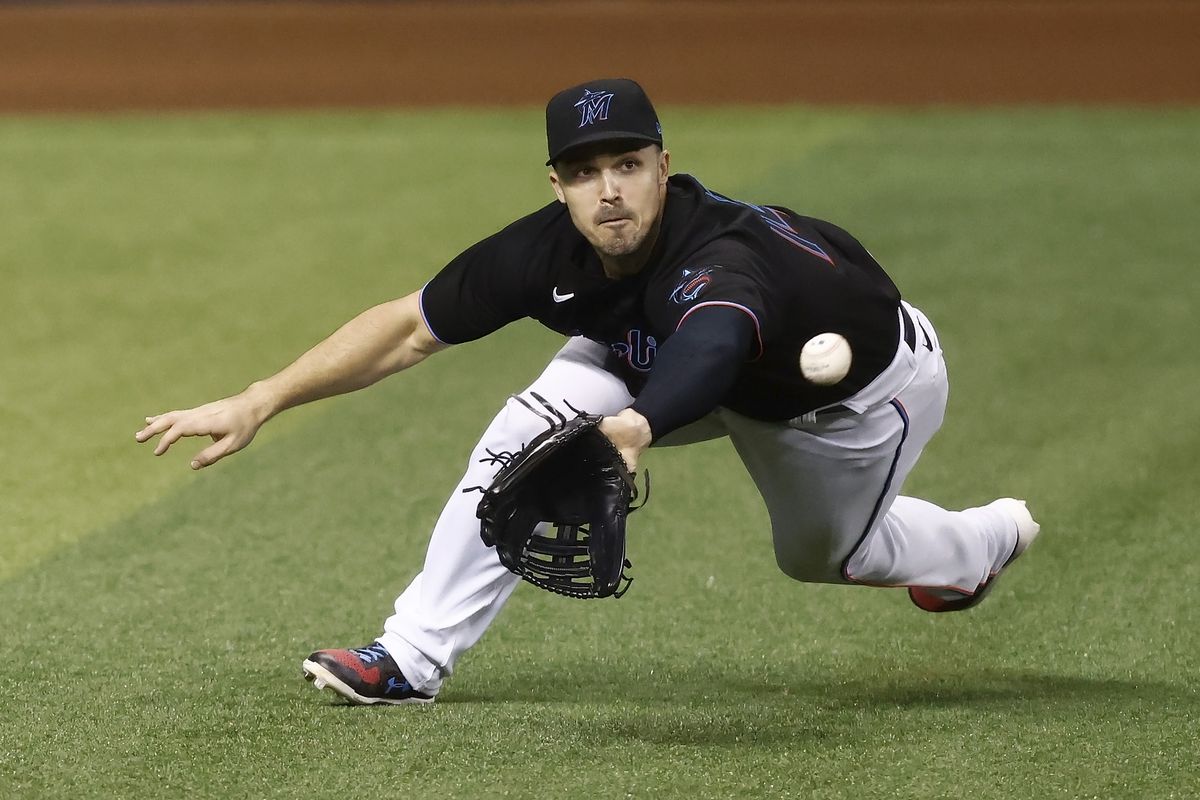 Adam Duvall #14 of the Miami Marlins dives to make a catch on a fly ball hit by Luis Urias #2 of the Milwaukee Brewers during the sixth inning at loanDepot park