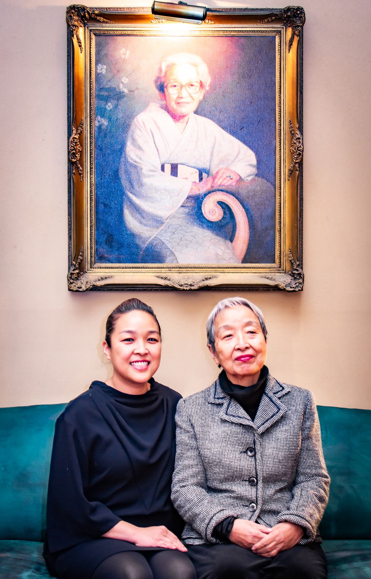 Sachiyo “Sachi” Nakato Takahara and Hiroe Nakato sit beneath a portrait of Tetsuko Nakato.