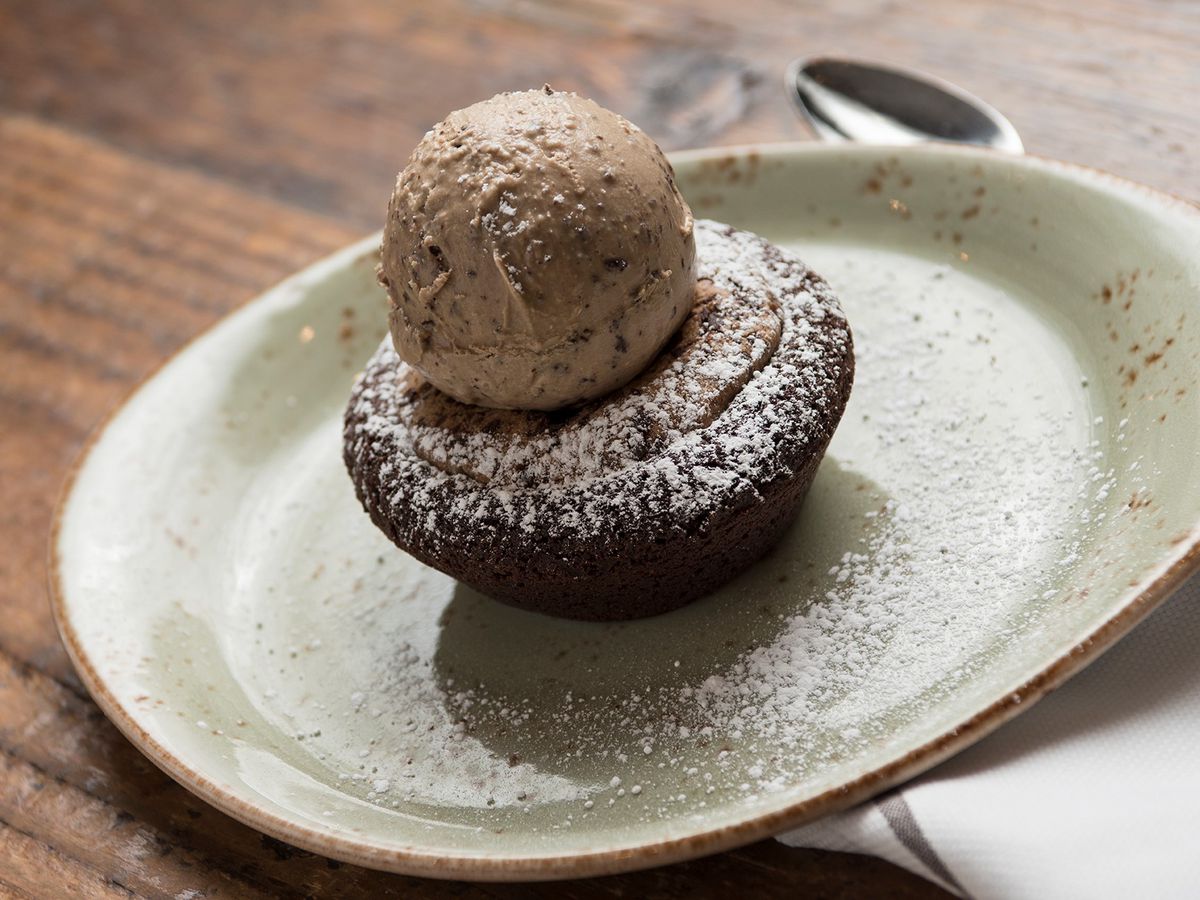 A brownie with chocolate ice cream on top