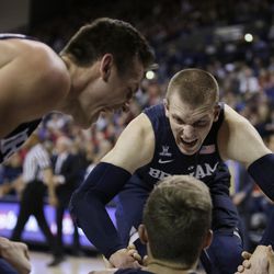 BYU's Nate Austin,top right, and Kyle Collinsworth, left, react while helping Chase Fischer up during the second half of an NCAA college basketball game against Gonzaga, Thursday, Jan. 14, 2016, in Spokane, Wash. BYU won 69-68. (AP Photo/Young Kwak)