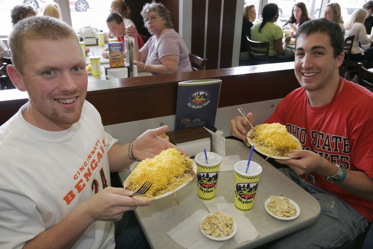 Two men with plates of food at the Skyline Chili Restaurant.