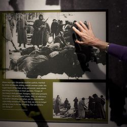 In this Thursday, April 25, 2013 photo, United States Holocaust Memorial Museum curator Susan Bachrach points out a 1942 photo of Ukrainian auxiliary police killing Jewish women under the supervision of German army personnel and in the presence of Hungarian troops during a preview of the new exhibit "Some Were Neighbors: Collaboration & Complicity in the Holocaust" in Washington. The exhibition, opening April 30, 2013, includes interviews with perpetrators of collaboration and complicity in the Nazi genocide. (AP Photo/Carolyn Kaster)