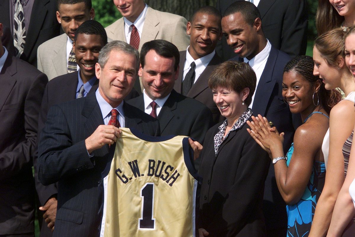 President Bush grins as he is presented with a personalized