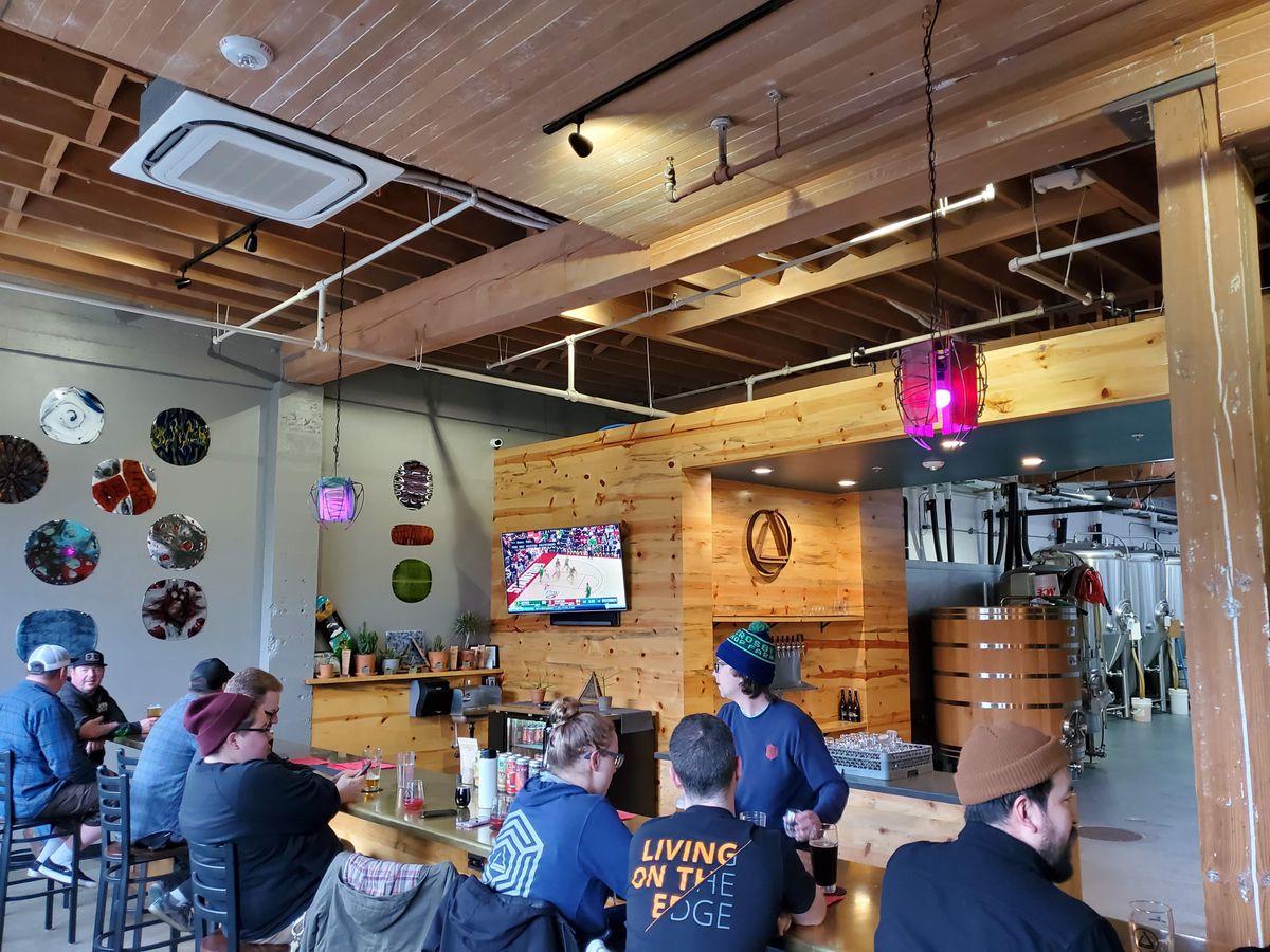 Bartenders and seated patrons are shown at Ruse Brewing.