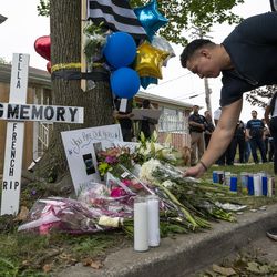 A police officer leaves flowers at the memorial erected to honor Officer Ella French.