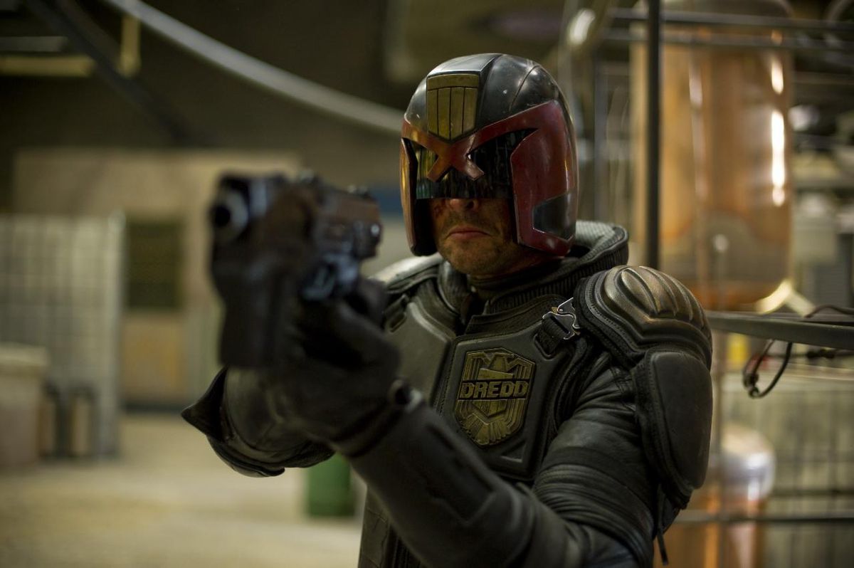 Karl Urban (Dredd) aims his pistol in Pete Travis’ Dredd (2012)