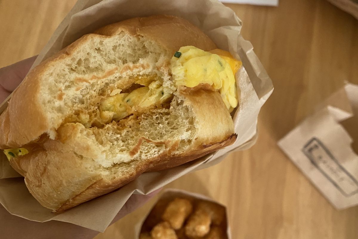 A vegetarian breakfast sandwich with tater tots.