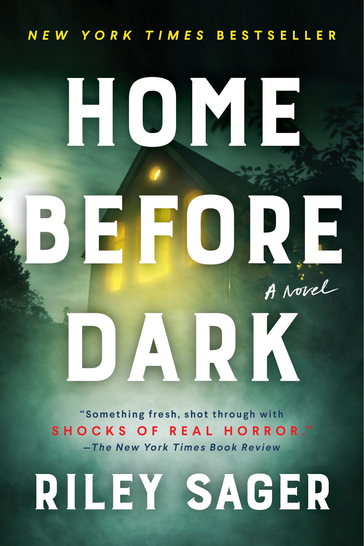 Cover image for Riley Sager’s Home Before Dark, which shows a house with the lights on obscured by fog.
