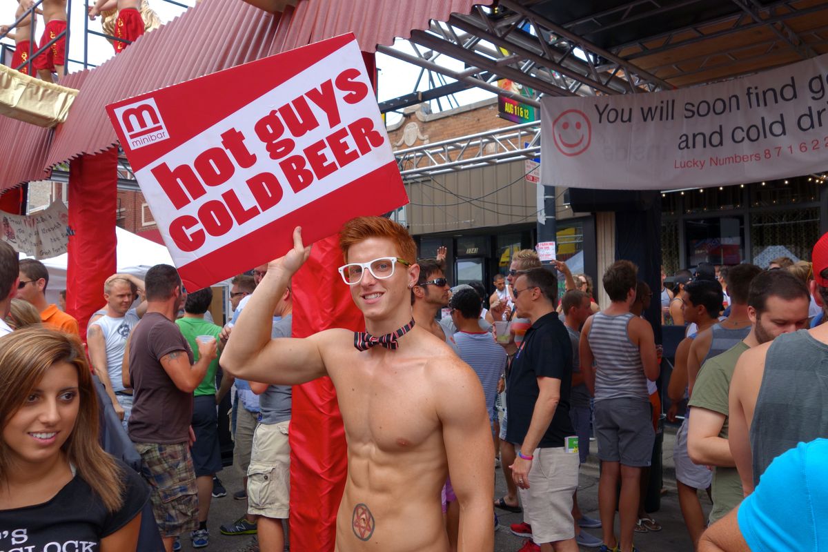 A shirtless man holding a sign “hot guys cold beer.”