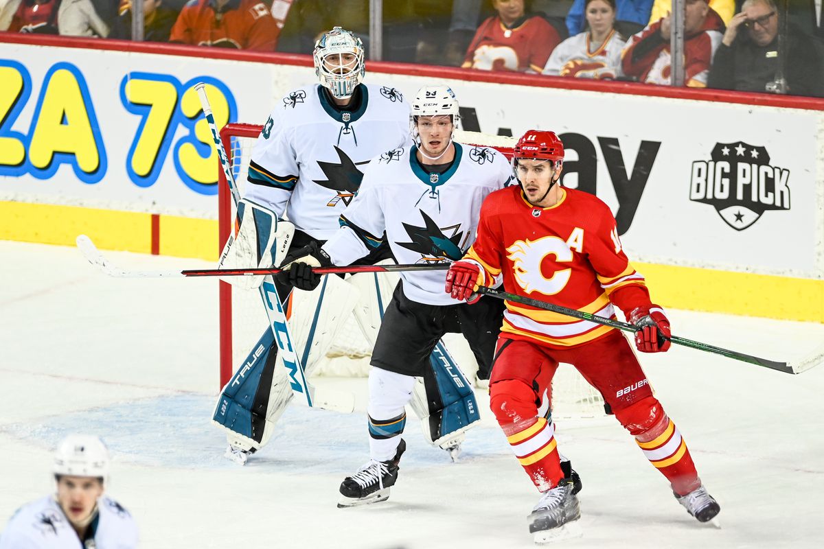 San Jose Sharks Defenceman Nicolas Meloche (53) and Calgary Flames Center Mikael Backlund (11) compete for position in front of San Jose Sharks Goalie Adin Hill (33) during the first period on November 9, 2021, at the Scotiabank Saddledome in Calgary, AB.