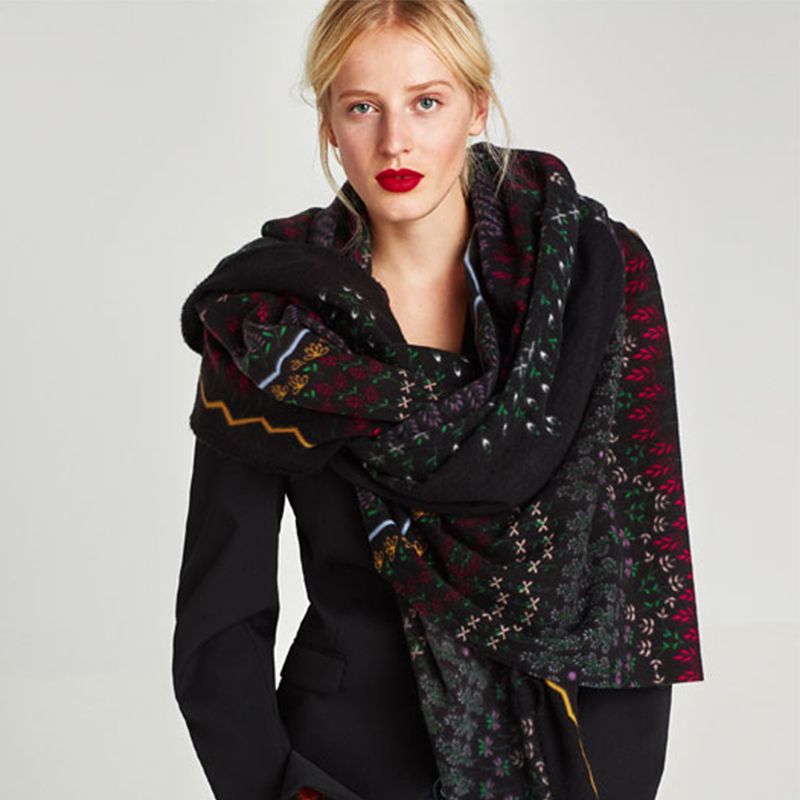 A dark floral scarf on a model. 