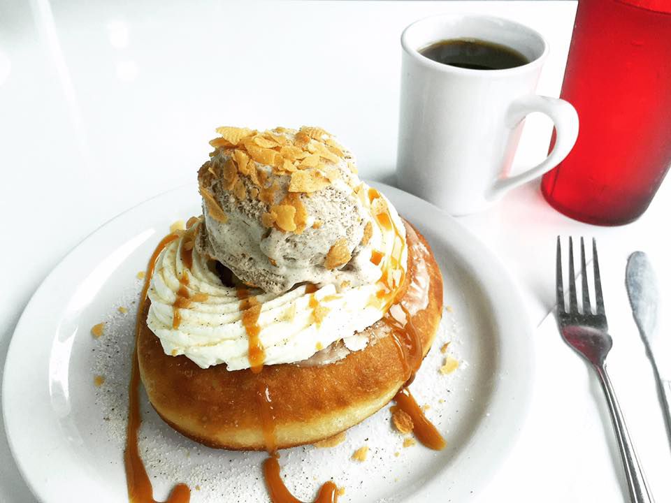 A doughnut topped with frosting and a scoop of ice cream