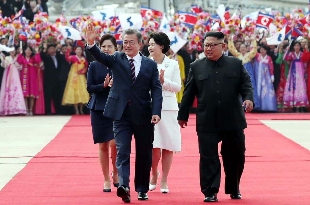 South Korean President Moon Jae-in waves at North Koreans who greeted him at the Pyongyang airport on September 18, 2018.