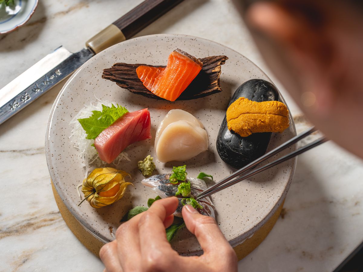 A chef plates sashimi.