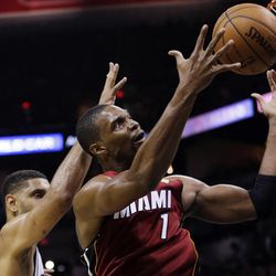 Miami Heat center Chris Bosh (1) grabs a rebound as San Antonio Spurs forward Tim Duncan defends during the first half in Game 1 of the NBA basketball finals on Thursday, June 5, 2014, in San Antonio. (AP Photo/Eric Gay) 