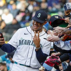 Seattle Mariners center fielder Julio Rodriguez (44) takes a selfie with fans before a game against the Cleveland Guardians at T-Mobile Park