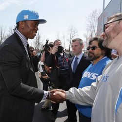 Ezekiel Ansah, the Detroit Lions first round draft pick meets Lions fans Mike Cesarz, right, and Mike Navalta, second from right, after arriving  at the team's training facility in Allen Park, Mich., Friday, April 26, 2013. Ansah, born and raised in Ghana, was selected fifth overall in the NFL draft on Thursday. 