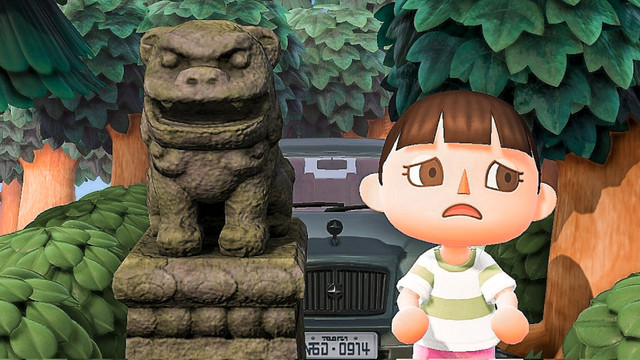 A recreation of Spirited Away’s Chihiro standing next to a stone dog, in Animal Crossing: New Horizons