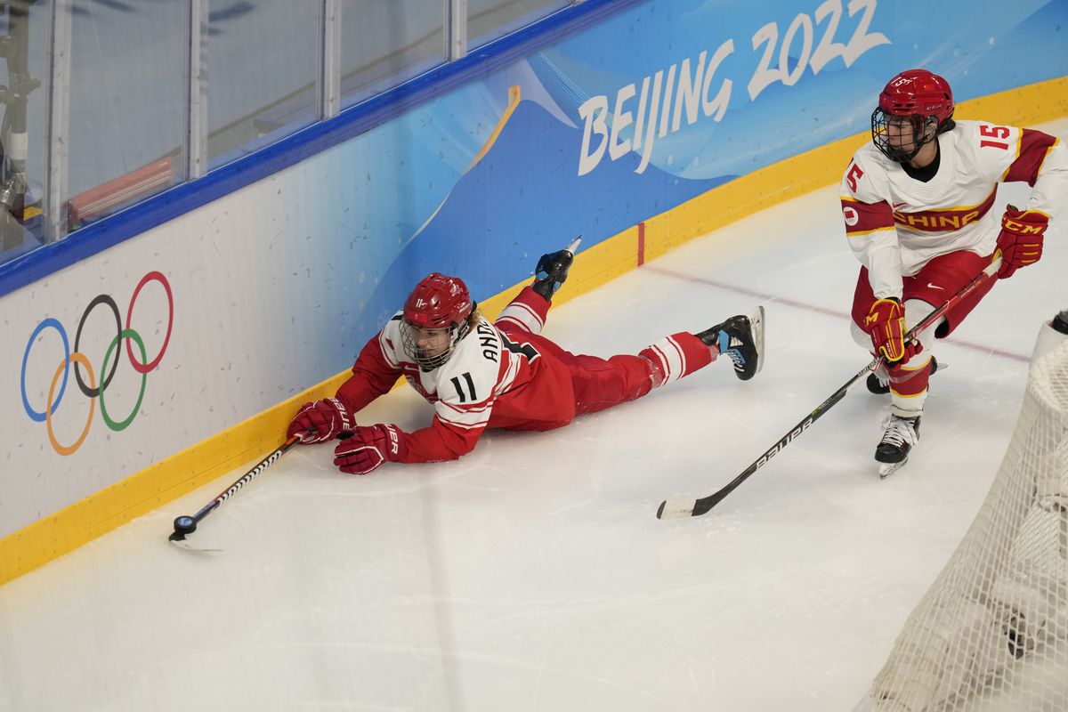 Baozhen Hu #15 of Team China skates the puck pass Amalie Andersen #11 of Team Denmark during their Women’s Preliminary Round Group B match at Wukesong Sports Centre on February 04, 2022 in Beijing, China.