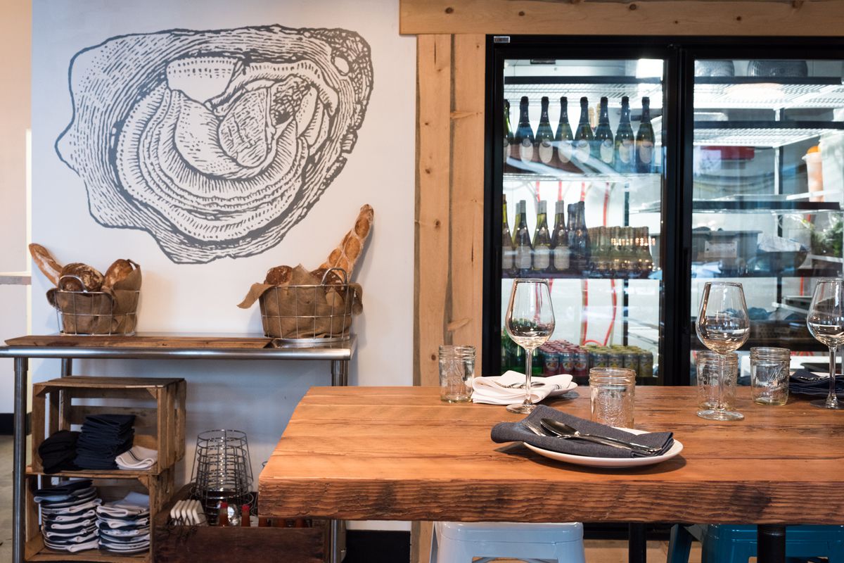 A picture of the interior of Olympia Oyster Bar, with its oyster mural and wine case