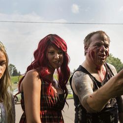 Zoe Stout, 12, left, Megan Lemon and Matt Stout take selfies before the 10th  annual Zombie Walk at Sugarhouse Park in Salt Lake City on Sunday, Aug. 6, 2017.
