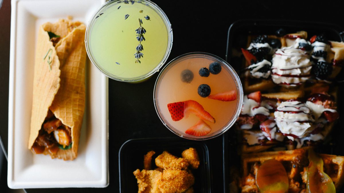 A variety of dishes that use waffles and some beverages shot from above.
