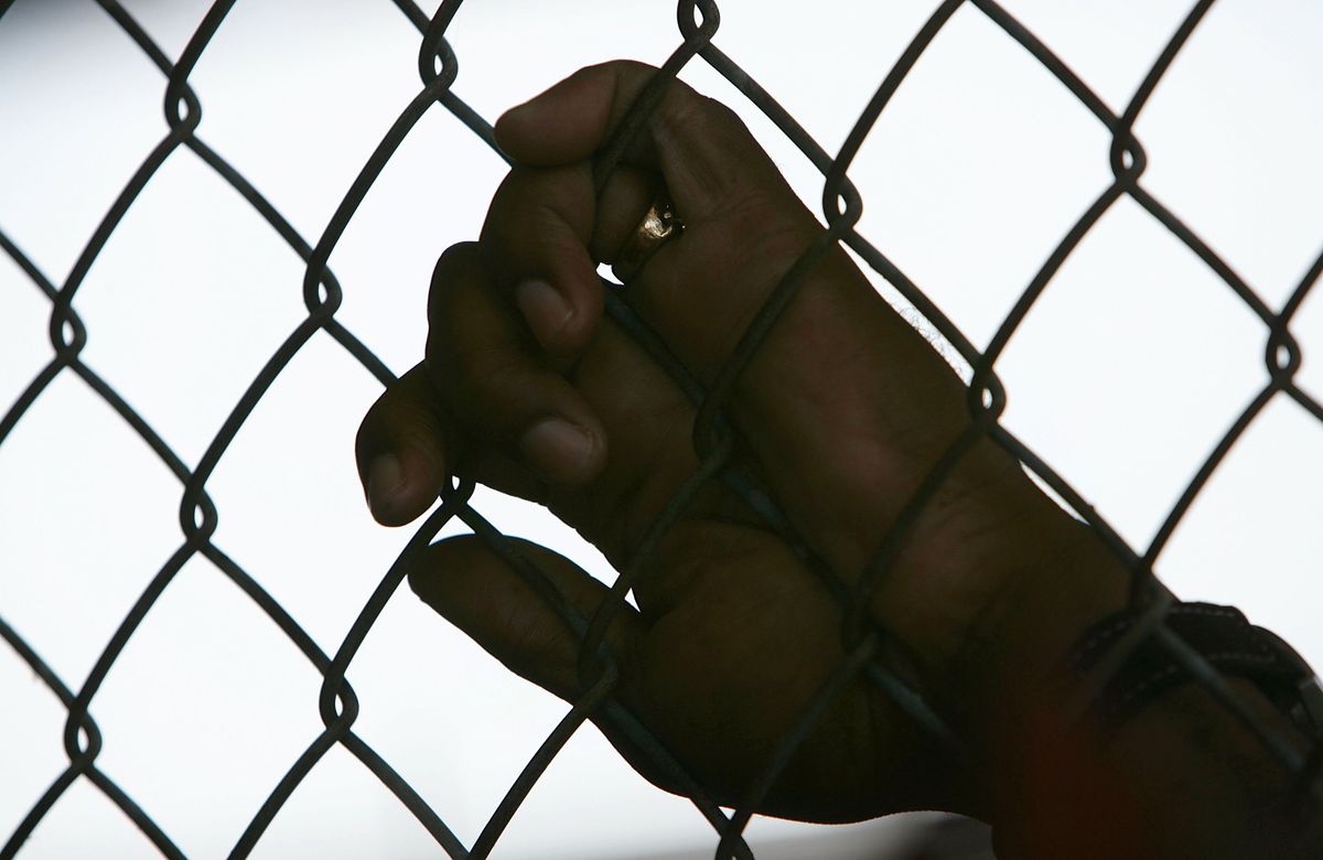 An inmate holds onto a fence at the Louisiana State Penitentiary.