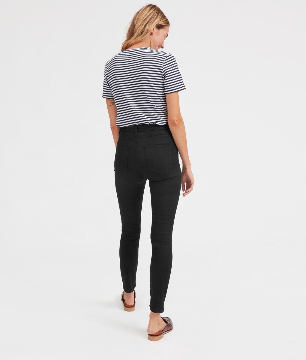 A model wearing black skinny jeans and a striped T-shirt