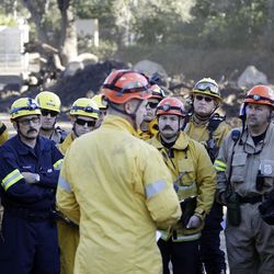 Search and rescue crews hold a meeting along Hot Springs Rd. in the aftermath of a mudslide Saturday, Jan. 13, 2018, in Montecito, Calif. (AP Photo/Marcio Jose Sanchez)