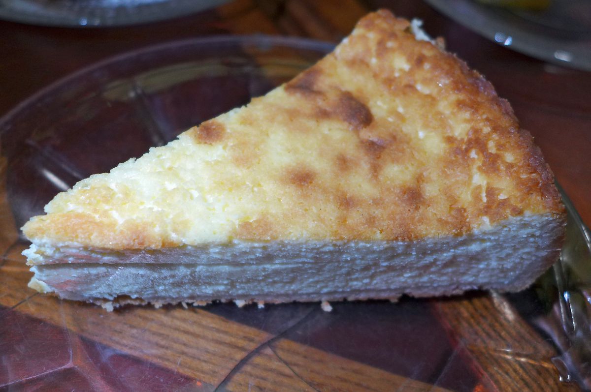 A wedge of cheesecake browned on top.