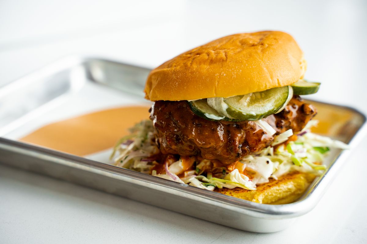 Fried chicken sandwich with pickles and slaw on a potato bun.