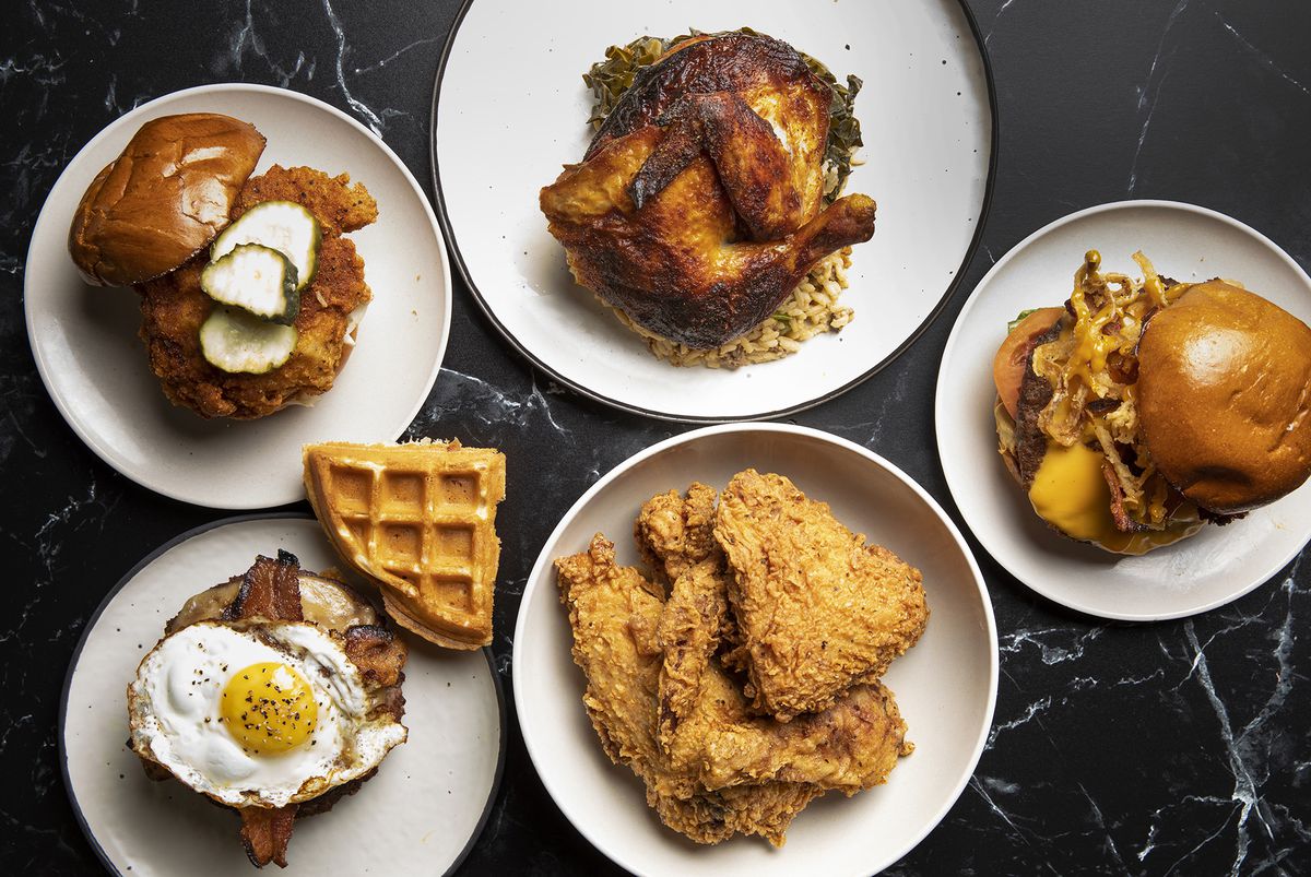 A layout of Pecking Order’s fried chicken, fried chicken sandwiches, and rotisserie chicken, plus two Craft Burger’s burgers — one topped with bacon and a fried egg.