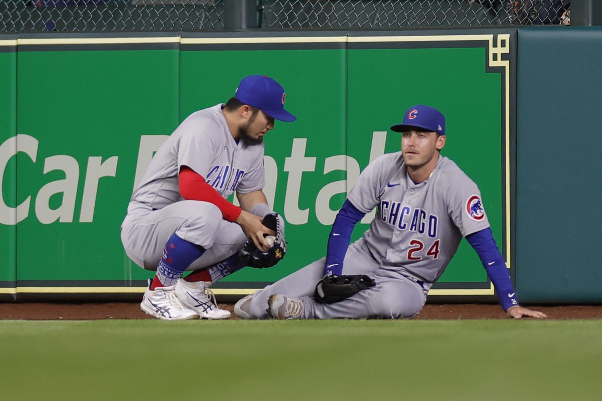 Cody Bellinger #24 of the Chicago Cubs is joined by Seiya Suzuki #27 after being injured on a catch during the seventh inning against the Houston Astros at Minute Maid Park on May 15, 2023 in Houston, Texas.