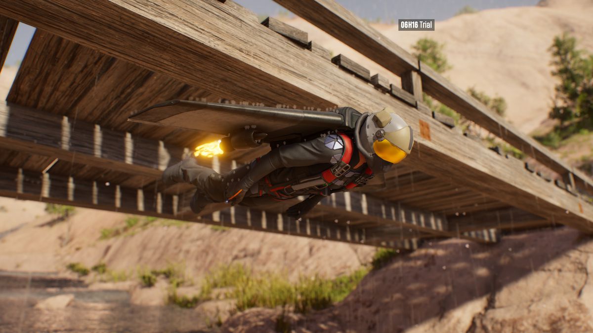 A person in a jetpack narrowly flies under a small wooden bridge in Riders Republic.